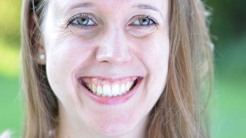 Agnes Jansen Frau mit langen blonden Haaren, trägt Perlenohrringe, vor grünem Hintergrund