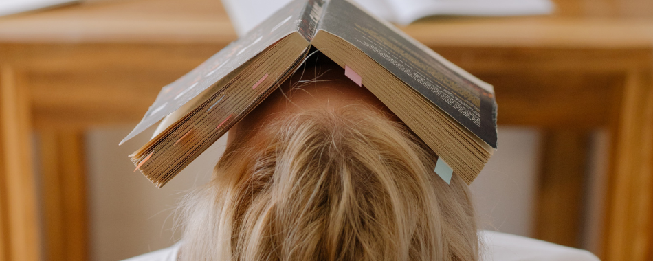 Frau liegt mit offenem Buch auf dem Gesicht, symbolisiert Mental Load im Blogartikel