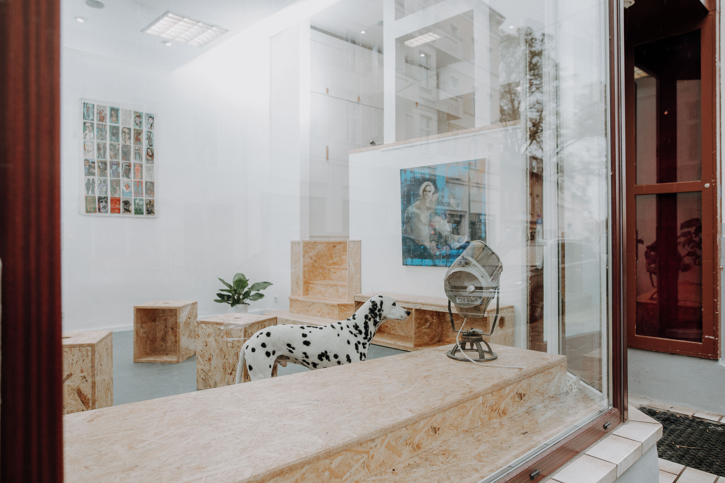 Moderner Coworking-Raum mit Holzregalen, Dalmatiner-Skulptur und gerahmtem Bild an der Wand